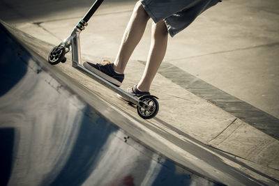 Low section of boy with push scooter in park