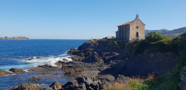 Panoramic view of sea and buildings against clear blue sky