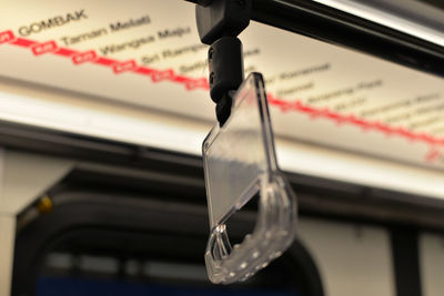 Close-up of handle hanging in bus