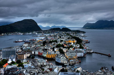 High angle view of city by sea and buildings against sky