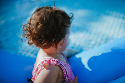 Rear view of woman with swimming pool