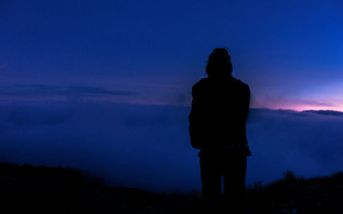 Rear view of silhouette man looking at sunset