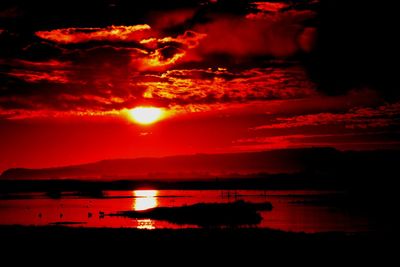 Scenic view of sea against dramatic sky during sunset