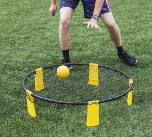 Low section of man playing with ball on trampoline