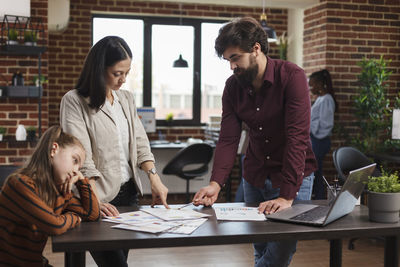 Male colleague explaining coworker at office