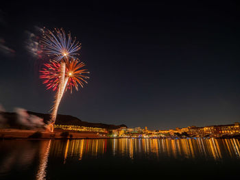 Firework display over river at night