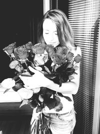Young woman holding bouquet of flower vase
