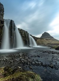 Scenic view of waterfall against sky