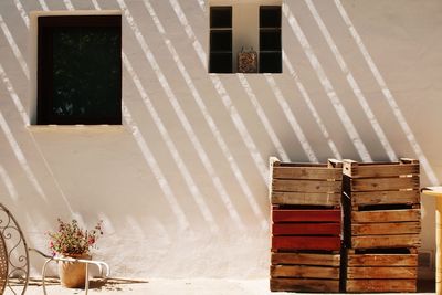 Stack of wooden crates against house wall