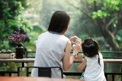 Rear view of mother and daughter outdoors