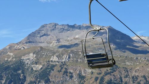 Overhead cable car over snowcapped mountains against sky