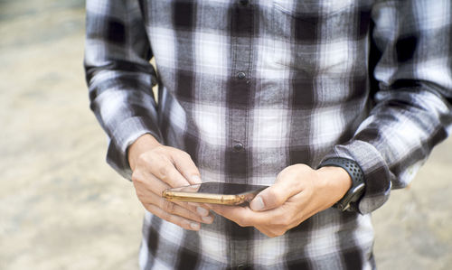 Midsection of man using mobile phone