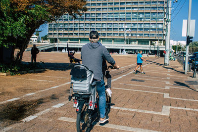 People on street against buildings in city