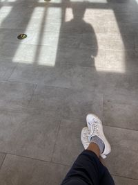 Low section of man standing on tiled floor