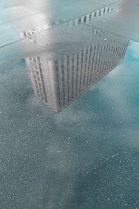 High angle view of modern building reflecting on wet street