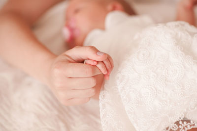 Woman holding hand of baby