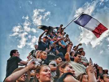 Low angle view of people standing against sky