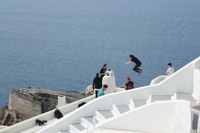 High angle view of people jumping over sea
