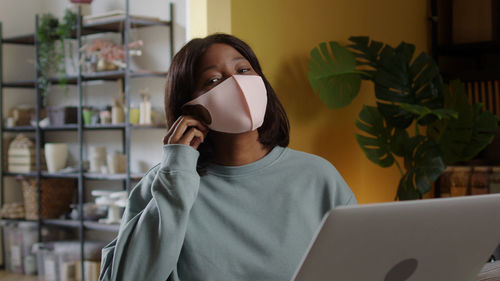 Portrait of young woman using laptop at home
