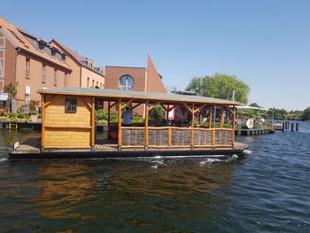 People on boat in river against clear sky