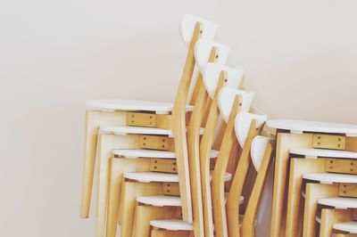 Close-up of empty chairs and table against white wall