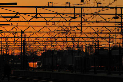 Railroad station against sky at sunset