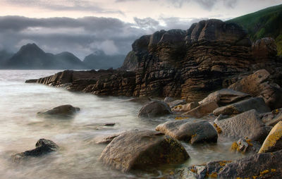 Rocks in sea against sky