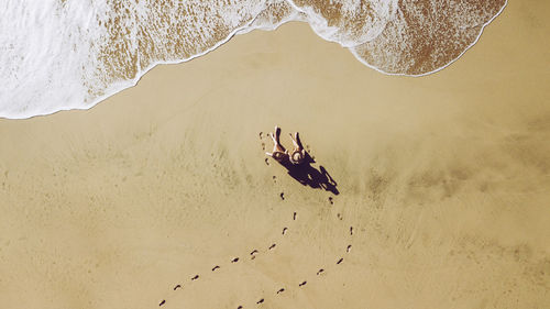 High angle view of couple sitting at beach