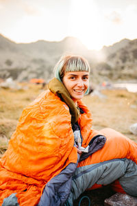 Portrait of young woman sitting on field