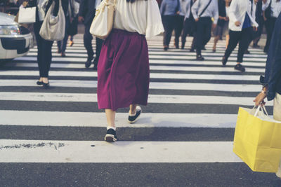 Low section of people walking on road