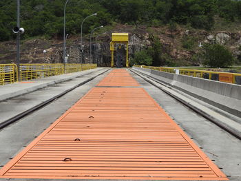 Empty footbridge against plants