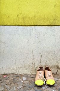 Shoes on street against wall