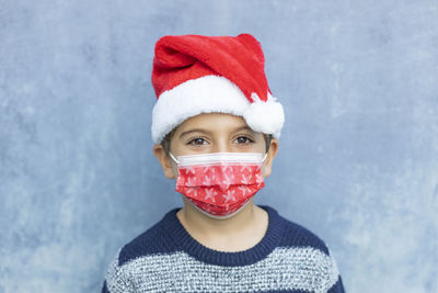Portrait of boy wearing mask standing against wall