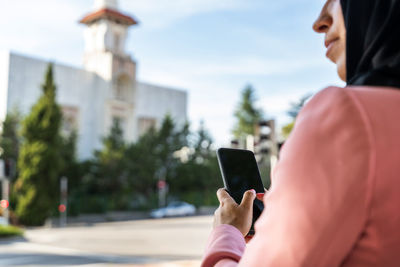 Midsection of person photographing with mobile phone