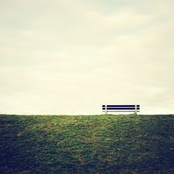 Empty park bench on field