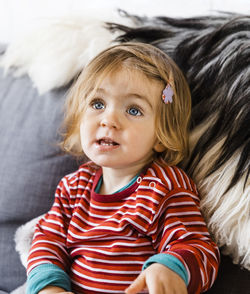 Cute girl sitting on sofa at home