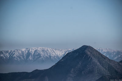 Scenic view of snowcapped mountains against clear blue sky