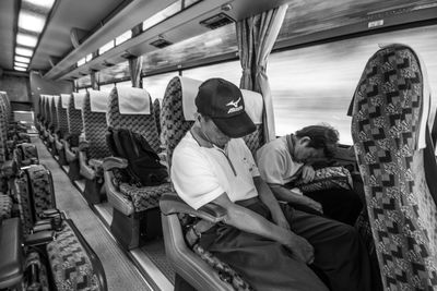 Rear view of people sitting in train