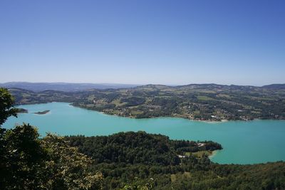 High angle view of river amidst trees against clear blue sky