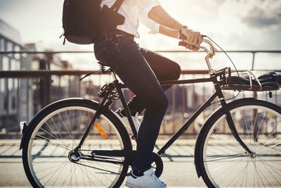 Low section of businessman riding bicycle on bridge