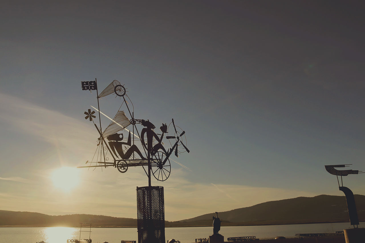 SILHOUETTE OF STREET LIGHT BY SEA AGAINST SKY