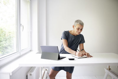 Portrait of young businesswoman using laptop at office