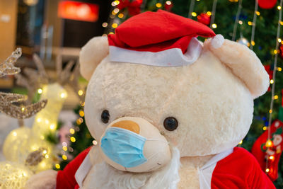 Teddy bear in santa claus suit wear face mask during christmas with pandemic covid-19 breakout
