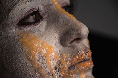 Close-up of human face against black background