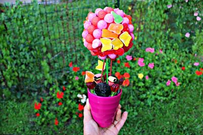 Cropped image of hand holding flower made of candies