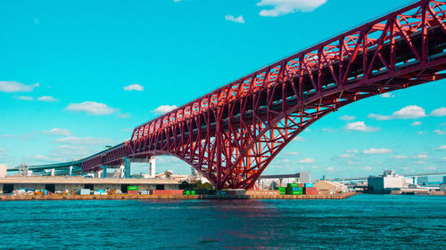 Arch bridge over river against sky