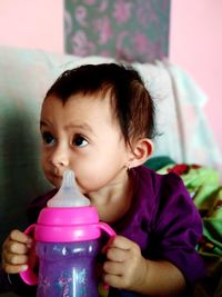 Close-up portrait of cute girl in pink drinking