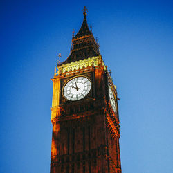 Low angle view of clock tower against blue sky