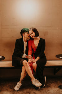 Young romantic stylish ladies having a romantic moment together while sitting on a bench