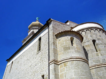Low angle view of bell tower against blue sky